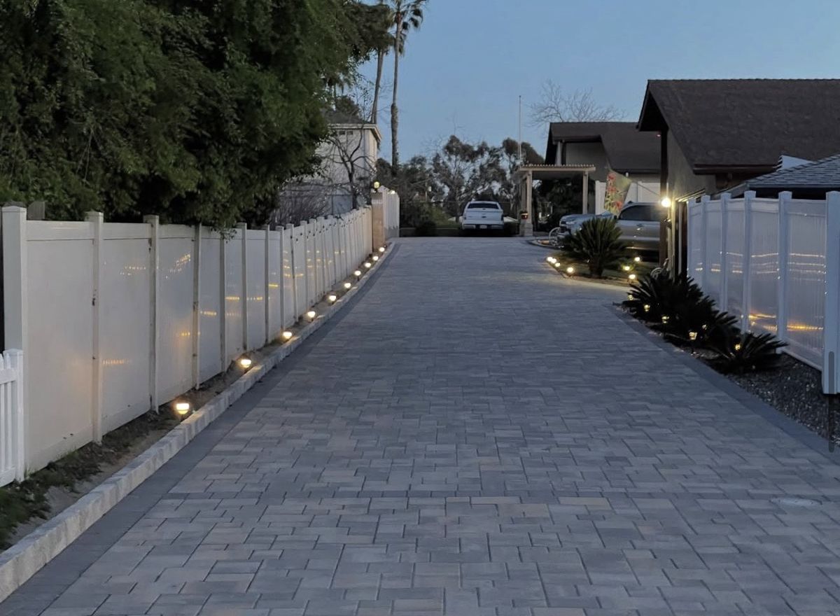 Driveway with vinyl fences and landscape lighting