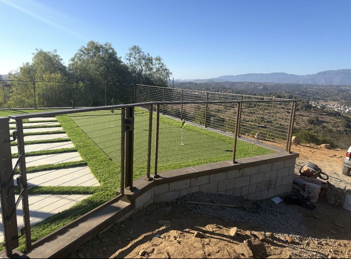 Bronze cable railing around a backyard putting green with mountain views